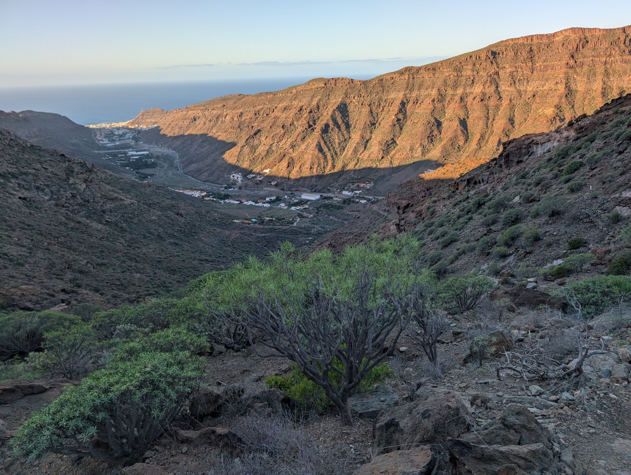 Sola begynner å komme over kanten av dalen. Puerto Mogan ligger helt nede ved sjøen
