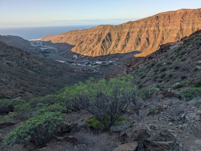 Sola begynner å komme over kanten av dalen. Puerto Mogan ligger helt nede ved sjøen
